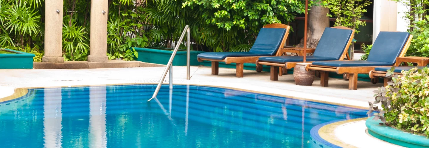 Blauer Pool mit Liegestühlen